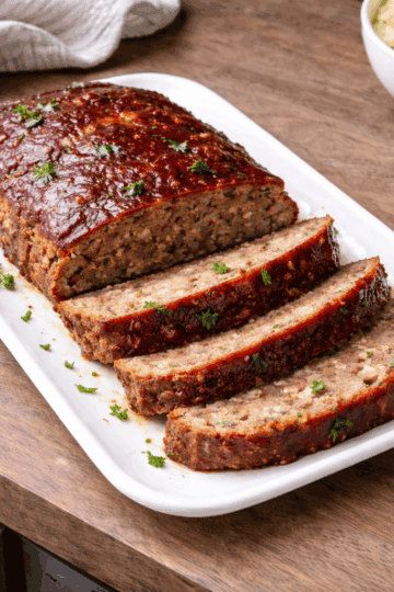 classic american meatloaf on a plater, holding together showing moist interior from panade technique