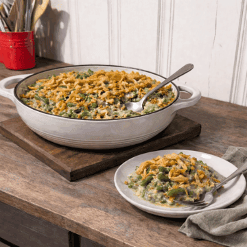 Green bean casserole with creamy mushroom sauce baked in a casserole dish, served on a small plate