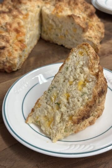 cheaddar sring onion irish soda bread with a slice out showing interior moist and crisp crust